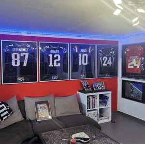 Eingerahmte Footballtrikots von Football-Legenden wie Rob Gronkowski, Tom Brady und Mac Jones. Eine sehr persönliche Hall of Fame.
