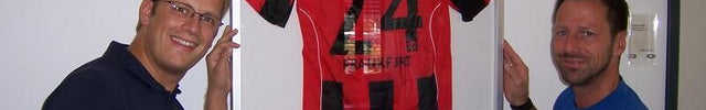 Uwe Bindewald vor Trikotrahmen im Sportleistungszentrum von Eintracht Frankfurt