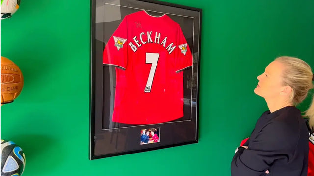 Diane Caldwell blickt auf ihr gerahmtes und signiertes David Beckham Trikot mit der Nummer 7 von Manchester United