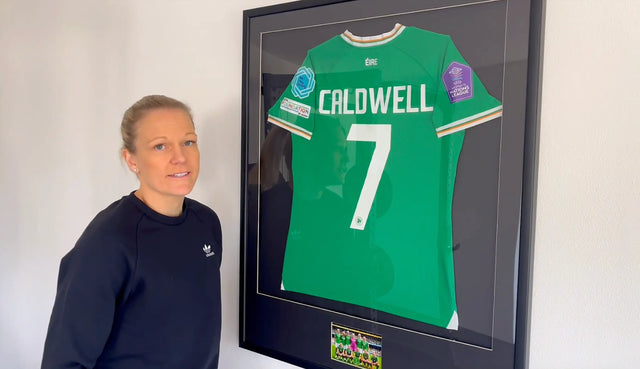 Diane Caldwell neben ihrem gerahmten irischen Nationalmannschafts-Trikot Nummer 7 mit Aufschrift Caldwell vom ersten Frauen-Länderspiel im Aviva Stadium